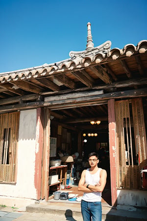 Asian man, glasses, handsome, (stubble:1.3), muscle, white tank top, (male focus), perfect proportions, perfect perspective, cinematic lighting, film photography, ((portrait, headshot)), subtropical environment, landscape, historical old cityscape, scenery, buildings, taiditional, historical, heritage, rustic, temple, multiple temples, court, atrium, Taiwanese temple, Hokkien architecture, (orange tiled roof, upward curve ridge roof, wooden structure), stone base, red brick wall, trees, blue sky