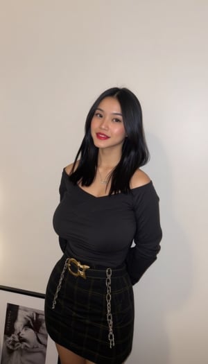 A young Asian woman stands confidently in front of a crisp white wall, dressed in a striking ensemble. Her long, dark hair cascades down her back as she wears a black off-the-shoulder shirt with long sleeves, paired with a plaid black skirt and matching belt featuring a gold buckle. A pop of vibrant red color accentuates her lips, drawing attention to her facial features. Around her neck, a silver chain adorns the necklace that catches the light. To her right, a framed black and white photograph of a woman's face adds an intriguing element to the scene, creating a sense of depth and visual interest.