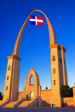 Monument with a monumental arch and a waving flag in the center, highlighting the Dominican flag with vivid, contrasting colors against a deep blue sky at sunset. The flag should be the main focus, with its red, white, and blue colors standing out clearly. Make sure the details of the flag are sharp and realistic, with lighting that makes it shine prominently in the scene. The monument in the background should be visible but not as conspicuous as the flag.