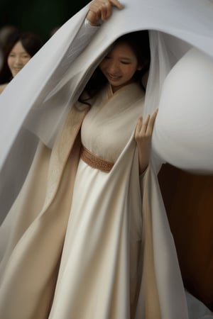 Asian bride’s head sinking getting covered buried underneath a large amount of flowing white veil cloak covered full body 