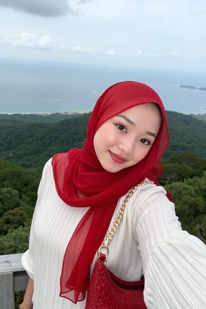 This is a high-resolution photograph featuring a young woman taking a selfie at an elevated viewpoint, likely a lookout or skywalk. The woman is of South Asian descent, with fair skin and a round face adorned with meticulously applied makeup, including bold, winged eyeliner and matte lipstick in a deep red shade. She wears a white, long-sleeve ribbed knit sweater and a voluminous, rich red hijab that flows gracefully around her, covering her head and shoulders. 

Her hijab is made of a lightweight, sheer fabric that allows for a soft, delicate texture contrasted against the knit sweater. She has a confident smile and is looking directly at the camera, capturing the moment with her right arm extended. She carries a woven, red leather handbag over her left shoulder, adding a pop of color to her outfit.

In the background, the scene extends to a breathtaking panoramic view of lush green forested hills and a vast body of water, likely a sea or lake, under a partly cloudy sky. The horizon is distant, with faint outlines of distant islands and the coastline. The overall mood of the image is serene and picturesque, highlighting both the beauty of nature and the woman's elegant attire.