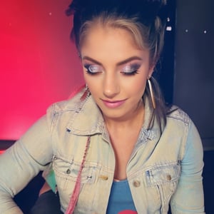 American woman 30 years old resembling Alexa Bliss, she is wearing levis jeans (short, tight, light blue color) and a ex-boyfriend levis denim jacket (light blue color), beautiful long hair, alexa bliss face, alexa bliss hairstyle, harley quinn makeup, posing, daylight, full body image, large hoop earrings, photoshoot