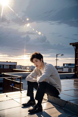 a young man sits outdoors, possibly on a rooftop, leaning forward with his arms resting on his knees. He wears a dark blazer over a white ribbed sweater, exuding a thoughtful or introspective mood. The photograph captures a soft, natural light and displays a subtle lens flare, adding an artistic touch to the serene moment.