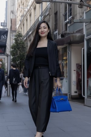 An elegant french young woman, refined style, in a London shopping street, holding her Birkin25 bag, royal blue color bag, swift leather bag, holding bag by hand, gold hardware Birkin bag