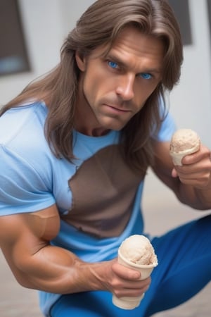 male brown long hair.
blue eyes.
muscular.
wearing a torn t shirt.
kneeling with an ice cream in his hand.
looking into the camera