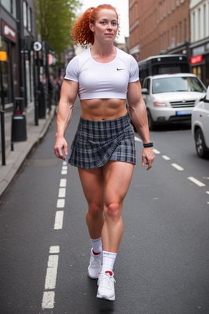 A heavily muscled female crossfit athletic, 
 red headed, ginger hair,  wearing a white t-shirt. BREAK plaid short skirt BREAK white ankle socks. BREAK black sneakers,  she is walking along the highstreet in an English city , there are other people walking 