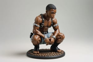 A full-color, delicately painted porcelain figurine depicting a kneeling, muscular 20-year-old black man in a leather harness and handcuffs and hands over head.The figurine is 6 inches high, barefoot, and exudes confidence and athleticism, with intricately detailed and perfect hands. It's displayed on a small white stand, placed on a coffee table in a party setting.