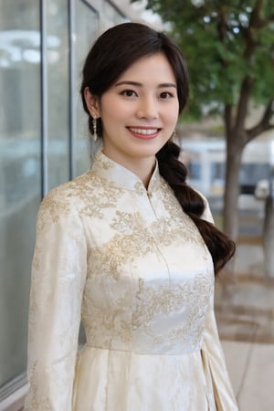 In the image, a woman is standing in front of a glass facade that reflects her image. She is wearing a traditional Chinese dress adorned with floral patterns and gold accents. Her hair is styled in a braid that rests over her right shoulder. The background suggests an urban environment, with a tree visible behind her. The overall tone of the image is bright and cheerful, highlighted by the woman's smile and the daylight setting.