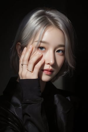 Asian portrait,A portrait of a person with short silver hair,partially illuminated by a narrow beam of light,wearing a black outfit,hand covers part of the face,showcasing minimalistic rings on fingers,makeup is subtle with attention on eyes and lips,expression appears contemplative,shadows enhance the dramatic effect,composition is intimate,color scheme relies on dark tones and highlights,the close-up angle emphasizes emotional depth,scene gives an artistic and moody vibe.