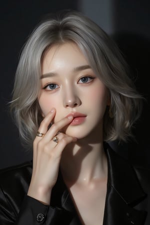 Asian portrait,A portrait of a person with short silver hair,partially illuminated by a narrow beam of light,wearing a black outfit,hand covers part of the face,showcasing minimalistic rings on fingers,makeup is subtle with attention on eyes and lips,expression appears contemplative,shadows enhance the dramatic effect,composition is intimate,color scheme relies on dark tones and highlights,the close-up angle emphasizes emotional depth,scene gives an artistic and moody vibe.