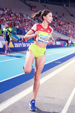 olympic Stadium,great crowds of spectators around the stadium,olympic emblem,track,1 girl,sprinter,blonde hair,blue eyes,long ponytail,wearing short and tight uniform( Text "PARIS 2024" written on her top),knee pads,running shoes,100meter sprint,she is running and crossing the finish line,lift both arms,smile,cowboy_shot,