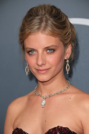 Melanie Laurent is at a gala ball, wearing a long dark blue silk dress with a V-neckline and a beaded embroidery. She wears a diamond necklace and long earrings with diamond details. She is wearing elegant makeup, with silver eyeshadow, black eyeliner, and a dark red lipstick. The image is in an elegant style, focusing on the dress, accessories, and pose of the actress. The lighting is soft, with warm tones, creating an atmosphere of luxury. The resolution of the image should be high, focusing on the sharpness and details of the clothing and accessories.