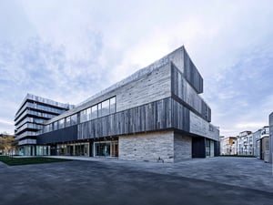A minimalist apartment complex rises from a flat, urban landscape. The modern structure's rectangular silhouette and clean lines define its flat, two-dimensional presence against the horizon. A subtle gradient of greys and blues in the sky echoes the building's uniform color palette.,best quality,dvarchmodern