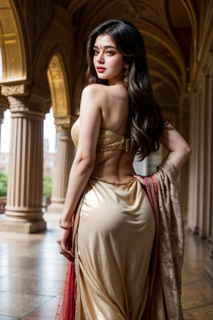 A majestic Bollywood actress stands proudly in a grand, ornately decorated palace courtyard, the warm golden light of sunset casting a flattering glow on her resplendent figure clad in a stunning golden lehenga. Her long hair cascades down her back like a river of night, as she holds a regal pose with one hand resting on her hip and the other adorned with intricate jewelry. The camera frames her majestically from a low angle, emphasizing her royal bearing and the opulence of her surroundings.