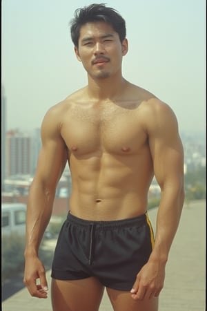 A (((full-body shot))) photograph of a mid-20s Korean young man in the 1960s. He is wearing short athletic shorts and no shirt. He has a small moustache. His burly, well-worked body stands out. Hair on his armpits, legs, chest and arms. The city can be seen in the background. Retro film, noise film, Kodak 400, 60s vibes.