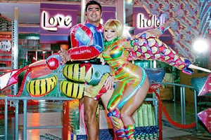 An award winning journalist Photograph, of a man and a woman wearing multi-colored inflatable outfits, in a funky love hotel having sexual intercourse, well lit cinematic lighting, complex shadows, extremely detailed , hotshoe flash on subject, text reads:"love hotel" , 1990s Photoshop style