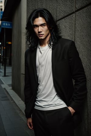 A realistic image of a young Asian man with long, wavy black hair, embodying the influencer persona. He has a slim body, dressed in a trendy outfit featuring trousers, a shirt, and a white t-shirt. The man poses confidently in front of a textured wall on a Seoul street, his gaze fixed on the camera. The composition captures his fashionable ensemble and the urban setting, with natural lighting accentuating the scene's authenticity.