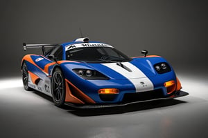 A blue, orange, and black, 1995 McLaren F1 GTR race car is parked in a dimly lit garage. The car has the number 41 on its side and is facing towards the right of the frame. The car is in front of a series of white lights that come from windows or doorways. The car is on a dark, gray floor. The car has a Michelin logo on the front, and a Kenwood logo below. The car's race number can be seen behind the front wheel. The car has an aggressive, aerodynamic design and a large rear wing. The image is likely from a car show or a magazine spread, as the lighting and composition make the car look very dramatic.