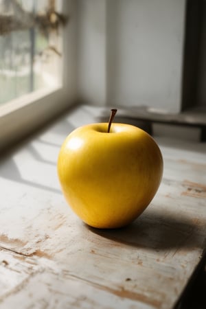 A still life photograph featuring a vibrant yellow as the primary color scheme. A single, bright yellow apple sits atop a distressed wooden table, illuminated by soft, warm natural light streaming through a nearby window. The composition is centered, with the apple placed directly in front of a shallow depth-of-field, blurring the background into a soft focus.