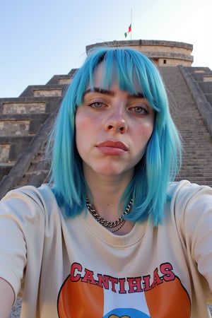 Billie Eilish taking a selfie in front of Teotihuacan. Blue hair. Wearing a shirt with Cantinflas on it. Mexican flag at background.