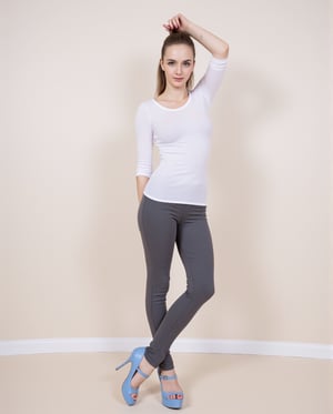 Here's the prompt based on your description:

"A 25-year-old woman stands confidently, dressed in a white top and gray pants. She completes her outfit with a pair of stylish blue shoes that add a pop of color. Her look is both modern and elegant, with a casual vibe that suits her age and personality. The setting around her is neutral, allowing her outfit and presence to be the focal points of the image."