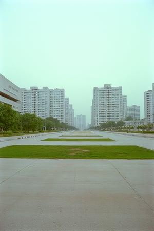 35mm Fuji Velvia film stock, 50mm f16 lens. An empty, cement city block in the middle of a city. Soviet-style Brutalist byuildings dot the background. The sky is a neutral gauzy gray.,RonFricke cinematic film style 