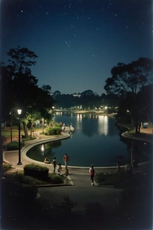 A 1990s nighttime view of Lake Garden in Malaysia, with the scene bathed in soft, ambient lighting. The lake is calm, reflecting the dim glow of nearby street lamps and the starry sky. The garden is serene, with trees and bushes casting long shadows. A few visitors stroll along the paths, their figures barely visible in the low light. The atmosphere is peaceful and tranquil, capturing the essence of a 1990s Malaysian night at Lake Garden.