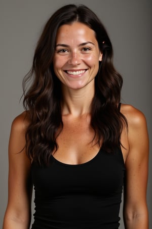 A 30yo woman with very long hair.
She has a cute round face with freckles and smiles.
She is wearing a tight fitting black sleeveless top made from smooth stretch fabric. 