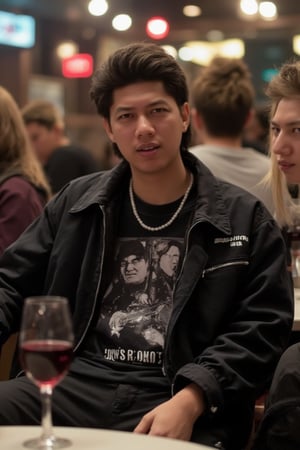 This guy is sitting in a bar, a glass of wine on the table, wearing a black oversized rock band t-shirt, black pants, a street style jacket, and a pearl necklace, with girls around him. 35mm 1.4