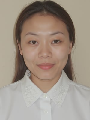 A close-up shot of a young Asian woman with long dark brown hair and brown eyes. She is wearing a white collared button down shirt with white embroidery on the collar. Her lips are a vibrant shade of pink. Her eyebrows are a light brown and her eyes are a darker shade of brown. She has a slight smile on her face. The backdrop is a light beige wall.