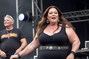 a plus size 50-year-old woman, Natural, curvy, tight (T-shirt), big chest, with long hair, at a music festival