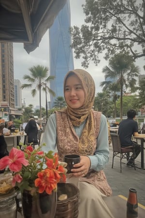 A warm close-up portrait of a hijabi woman, her bright smile radiating joy as morning light dances across her face beneath the towering pine tree's gentle shade. Her long scarf flows gently around her neck. She cradles a cup of coffee in her light blue office attire against the vibrant decorations of her cozy stall set amidst the urban landscape of MERDEKA tower at Kuala Lumpur city, where MRT railway tracks weave through the metropolis and flowers spill onto the pavement.