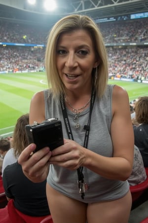 Sara Jay took a selfie, at the edge of her torso, in a football stadium, she supported the camera with a selfie