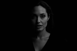 Black and white portrait of Angelina Jolie, dark background, shadow play, soft lighting, cinematic style