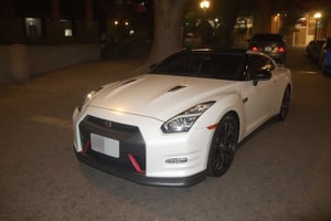 Photo of the Nissan GT-R R35 car painted shiny white, matte black grille and shiny black rims, full body night photo, this photo was taken right at night