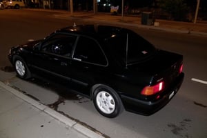 photo of Honda civic estilo 1992-1995, shiny black paint, white rims, parked on the side of the road, photo taken at night with a cellphone flash