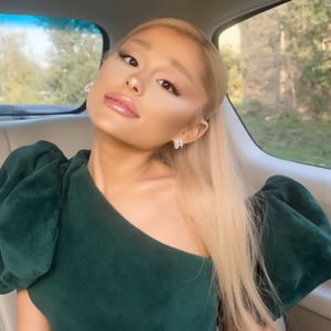 arianagrande 2024 style blonde with a down tail hairstyle ,Ariana Grande selfie, herself taking her picture, her inside a car, With a green dress, The background is a car, sun lighting, 4k quality, 4k detailed, realistic, best quality