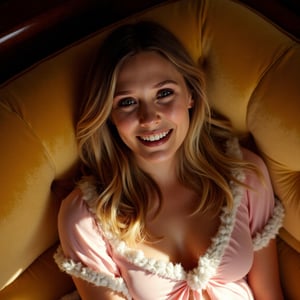 A warm glow illuminates Elizabeth Olsen's radiant face as she reclines on a plush velvet couch, wearing a soft pink nightgown adorned with delicate fluffy white trim. The camera frames her from above, capturing the gentle curves of her smile and the subtle vulnerability in her eyes. The golden lighting casts a flattering sheen on her skin, while the muted tones of the surroundings allow her beauty to take center stage.