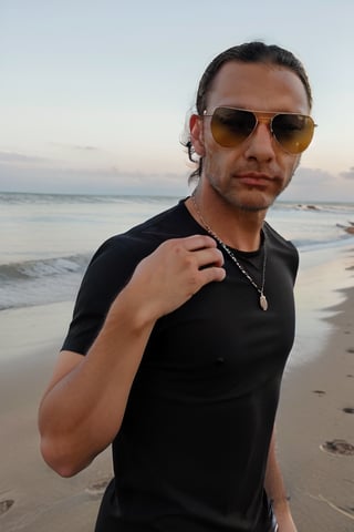 man long hair black shirt with sunglasses on a beach