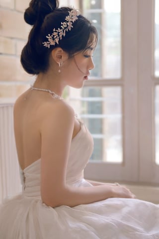 1girl, solo, black hair, hair ornament, dress, holding, jewelry, sitting, flower, earrings, indoors, necklace, hair bun, white dress, tiara