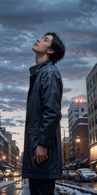 A man, wearing a coat, in the autumn, in a sad city, looking up at the sky as snow is falling.