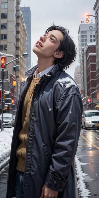 A man, wearing a coat, in the autumn, in a sad city, looking up at the sky as snow is falling.