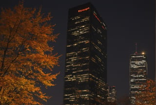 Night, autumn, skyscrapers with orange windows, lanterns illuminate the foliage of the trees and are reflected in the glass of the skyscrapers