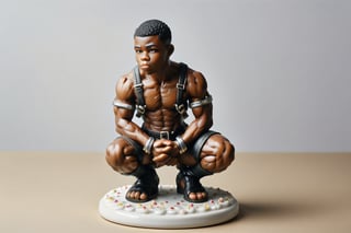 A full-color, delicately painted porcelain figurine depicting a kneeling, muscular 20-year-old black man in a leather harness and handcuffs and hands over head.The figurine is 6 inches high, barefoot, and exudes confidence and athleticism, with intricately detailed and perfect hands. It's displayed on a small white stand, placed on a coffee table in a party setting.