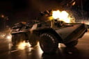 analog gloomy photo of a black eight wheeler (BTR-80, <lora:btr80:1>), from behind, racing down a neon city avenue at night,  shooting, buildings on fire, outrun, explosions in the background, High Detail, Sharp focus, ((photorealism)), realistic, best quality, 8k, award winning, dramatic lighting, epic, cinematic, masterpiece, dutch angle, ambient fog:1.5, volumetric lights, 