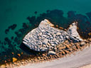 big stylized light grey shape of a fish made of rocks, landartAerial, rocks, beach, water, river, road, sea, island<lora:xl_more_art-full-beta3_1_0.5:1>
