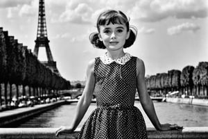 B & W Photo of a young 2yo Audrey Hepburn in a polkadot summer dress in Paris, Eiffel Tower in the background, Canon 5d Mark 4, Kodak Ektar
