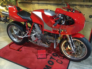 This 2001 Ducati MH900e is number 194 of 2,000 produced,  Finished in red with silver graphics, the bike is powered by a 904cc desmodromic L-twin paired with a six-speed transmission. Equipment includes five-spoke 17″ Antera wheels, Marelli electronic fuel injection, triple Brembo disc brakes, a Showa fork, and an adjustable Paioli monoshock as well as clip-on handlebars, a steering damper, a front fairing, a black solo seat, and a side stand.
