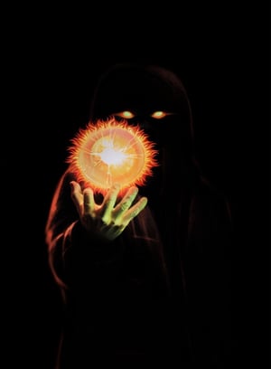 dark hooded man with glowing Eyes blacked out face are only can see the eyes of fire red and yellow holding a fire ball
