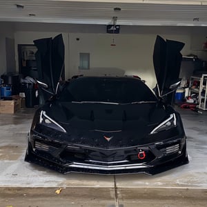 a close up of a black sports car parked in a garage, front view dramatic, front on, front profile shot, extremely detailed frontal angle, front side views full, cinematic front shot, stealthy, extreme detailing, sharp and detailed, front profile, vantablack gi, wrapped in black, octa 8k, front shot, front profile!!!!